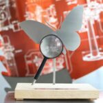 Schmetterling und Lupe stehen beim Sieglinde Vollmer Preis symbolisch für den Forschergeist, den Jugendliche bei außerschulischen MINT-Projekten aufbringen.